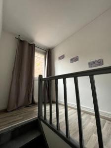 an empty room with a staircase and a window at Le coin cosy 38 m2 in Orchies