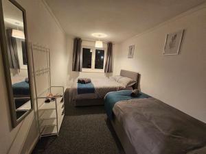 una piccola camera con due letti e uno specchio di Airport,NEC,JLR,Bham. Entire house 5 beds. a Kingshurst