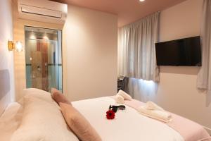 1 dormitorio con 1 cama y TV en la pared en Boutique Rooms Playa Burriana, en Nerja