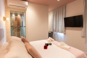 a bedroom with a bed with a tv on the wall at Boutique Rooms Playa Burriana in Nerja