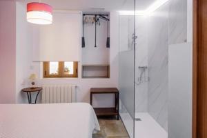 a bedroom with a shower and a bed with a glass door at Ca iaia Rosario - Casa rural con catas premiadas, obrador y senderismo in Cuatretondeta