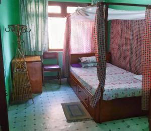 - une chambre avec un lit à baldaquin et une fenêtre dans l'établissement Sanu House, à Pātan