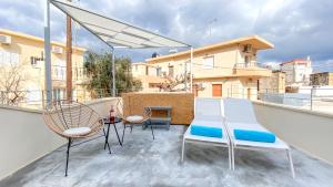 a patio with chairs and a table on a balcony at Sun Stone Villas in Chania Town