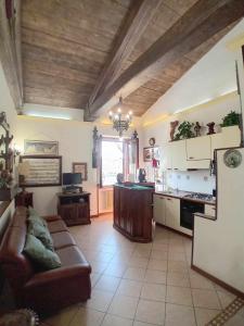 a living room with a couch and a kitchen at Casa Serafina trilocale con arredi d'arte e parcheggio privato in Orvieto