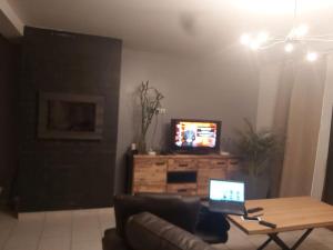 a living room with a couch and a laptop on a table at Grande maison jusqu'à 9 pers in Ézy-sur-Eure