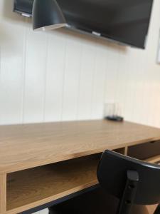 Habitación con escritorio de madera y silla negra. en Herøy Brygge, 