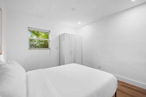 biała sypialnia z łóżkiem i oknem w obiekcie Awesome 1BR Apartment @Sailboat w mieście Fort Lauderdale