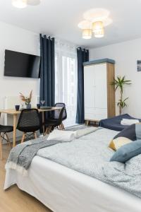 a bedroom with a bed and a dining room with a table at Apartament November, A4 in Lublin