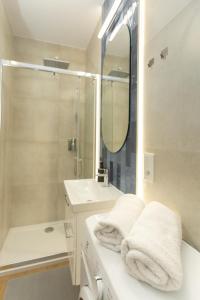 a bathroom with a sink and a shower and towels at Apartament November, A4 in Lublin +12 photos