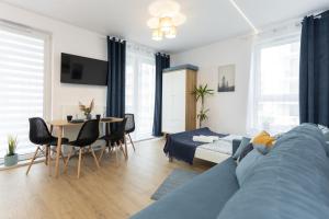 - un salon avec un canapé bleu et une table dans l'établissement A4 Apartament November, à Lublin