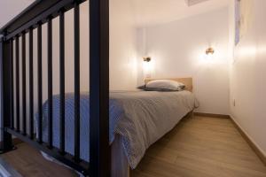 um pequeno quarto com uma cama e uma escada em Charmant T1 Mezzanine Neuf Clim 06 - Centre ville em Montpellier