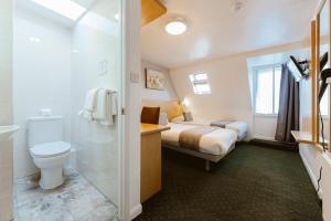 Un baño con una cama, un inodoro y un lavabo. en Star Hotel, en Londres