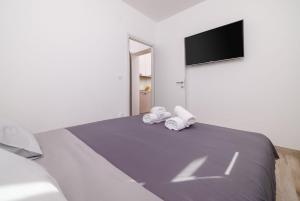 Tribalj的住宿－Apartments Margita 2，一间卧室配有一张床,上面有两条毛巾