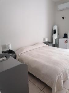 a bedroom with a large white bed with two tables at Hotel Marko in Loutraki