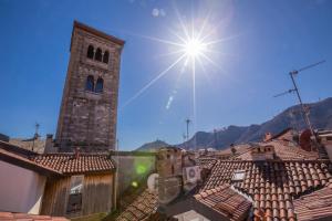 a building with a clock tower on top of roofs at Medioevo In Centro in Como