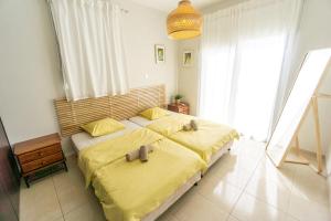 a bedroom with a large bed with yellow sheets at 2-bedroom apartment with pool in Paphos City