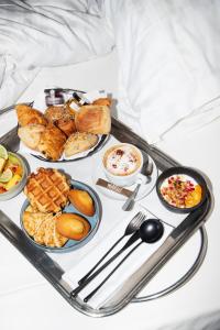 a tray of breakfast foods on a bed at New Hotel of Marseille - Vieux Port in Marseille