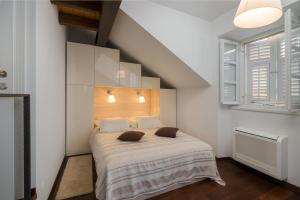a bedroom with a bed with white sheets and a window at Nije preša apartment 3 in Dubrovnik