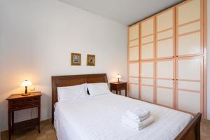 a bedroom with a white bed with two night stands at Kazamia Apartments with Sharing Pool in Agia Fotia