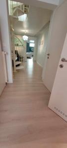 einen leeren Flur eines Apartments mit weißen Wänden und Holzböden in der Unterkunft Bruxelles ma belge in Brüssel