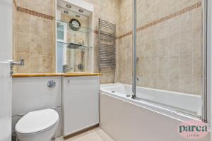 ein Badezimmer mit einem WC, einer Badewanne und einer Dusche in der Unterkunft Parea Living - Canary Wharf, Secluded Luxury Flat w Free Parking & Remote Working in London