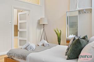 ein Schlafzimmer mit einem Bett mit Handtüchern darauf in der Unterkunft Parea Living - Canary Wharf, Secluded Luxury Flat w Free Parking & Remote Working in London