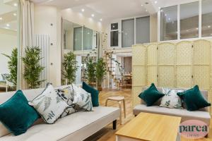 sala de estar con sofá blanco y almohadas verdes en Parea Living - Canary Wharf, Secluded Luxury Flat w Free Parking & Remote Working en Londres