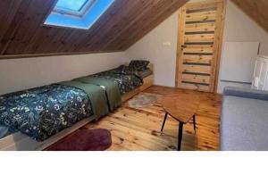 a bedroom with four beds and a wooden floor at Apartament Inna Droga in Walim