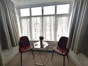 duas cadeiras e uma mesa em frente a uma janela em The Saxby Hotel em Skegness