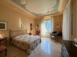 um quarto com uma cama, uma secretária e uma janela em Villa Doria 16Pax Waterfront by VILLASRETREATS em Portovenere