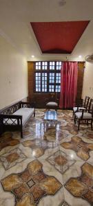 a room with a large tile floor with chairs and tables at HOTEL RIZ VARANASI in Varanasi