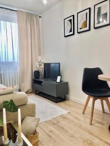 a living room with a television and a chair at Apartament lovely space in Rzeszów