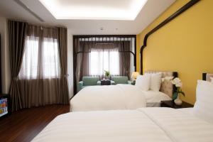 a hotel room with two beds and a window at PALAGO BOUTIQUE HOTEL in Hanoi