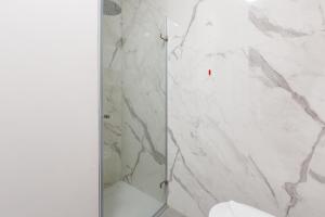 a bathroom with a shower with white marble at GuestHost - Cordusio Enchanting Apartment in Milan +14 photos