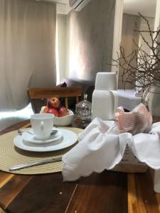 a table with a cup of coffee and a bowl of fruit at Apartamento Na Praia - VG FUn residence in Fortaleza
