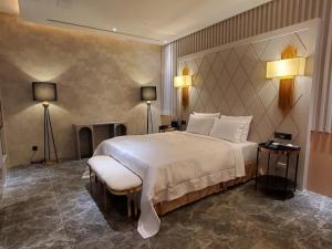 a bedroom with a large white bed and a fireplace at Domo Hotel in Taichung