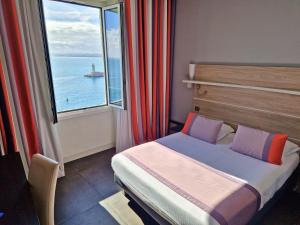 a bedroom with a bed and a large window at Hotel Le Saint Paul in Nice +29 photos