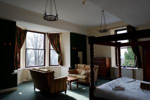 um quarto com uma cama, uma cadeira e janelas em Broomhall Castle Hotel em Stirling