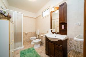 ein Badezimmer mit Waschbecken, Toilette und Dusche in der Unterkunft Villetta Iris by Vivimy in Taviano