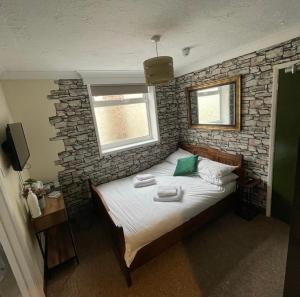 una cama en una habitación con una pared de piedra en Hotel Of Wizardry, en Great Yarmouth