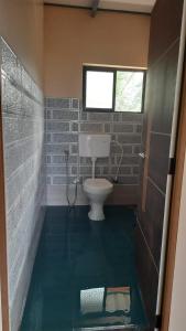 a bathroom with a toilet and a window at Samruddi Homestay in Kalasa