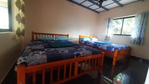 a bedroom with two beds and a window at Samruddi Homestay in Kalasa