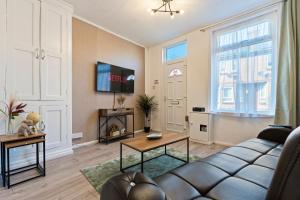 sala de estar con sofá y mesa en STAYZED N - NG7 Cosy Home, Free WiFi, Parking, Smart TV, Next To Nottingham City Centre, Ideal for Long Stays, Lots of Amenities, en Nottingham