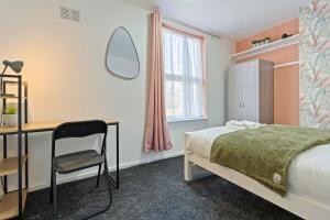 a bedroom with a bed and a desk and a chair at STAYZED N - NG7 Cosy Home, Free WiFi, Parking, Smart TV, Next To Nottingham City Centre, Ideal for Long Stays, Lots of Amenities in Nottingham