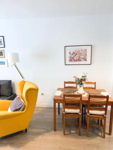 マラガにあるCéntrico apartamento con parking disponible by beBalmyのダイニングルーム(テーブル、黄色い椅子付)