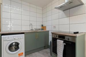 a kitchen with a washing machine and a sink at STAYZED N - NG7 Cosy Home, Free WiFi, Parking, Smart TV, Next To Nottingham City Centre, Ideal for Long Stays, Lots of Amenities in Nottingham