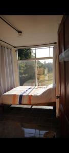 Bett vor einem Fenster in einem Zimmer in der Unterkunft Epimoni in Poás