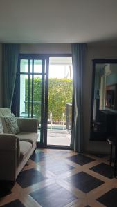 a living room with a couch and a large glass door at Espana Condo Resort Pattaya Sai2 in Pattaya South