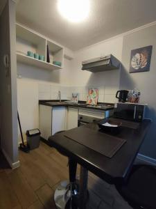 a small kitchen with a black table in a room at Lindo y cómodo departamento a pasos del metro in Santiago