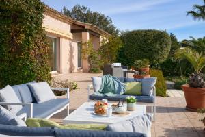 une terrasse avec deux canapés bleus et une table dans l'établissement Sunlight Properties - Villa Belvédère, à Peymeinade